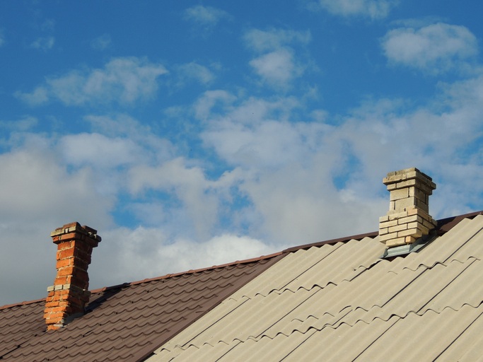 A shingle roof has two chimneys in Gresham, OR