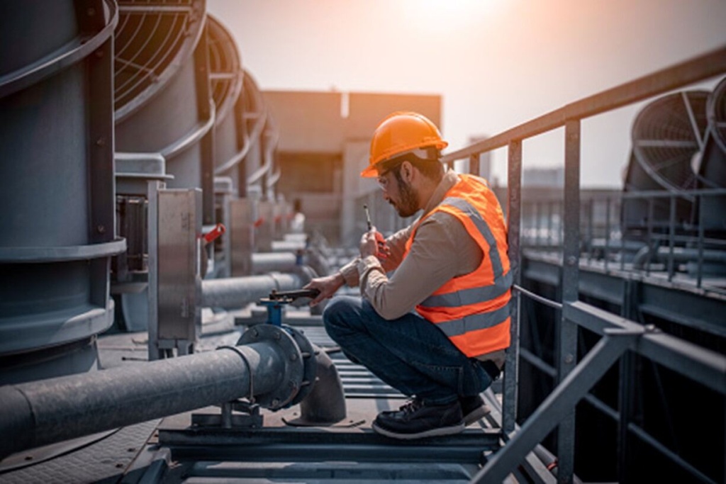 A man is repairing a pipeline of a commercial roof in Gresham, OR
